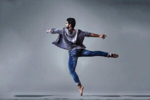 man wearing blue jeans doing pirouette spin