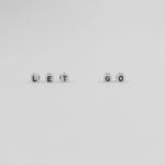 a let go slogan spelled with letter dice on white background