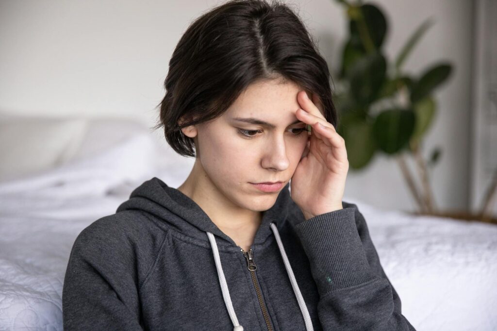 photo of woman touching her head