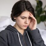 photo of woman touching her head