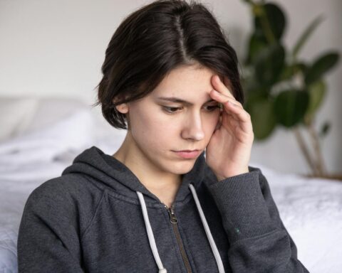 photo of woman touching her head