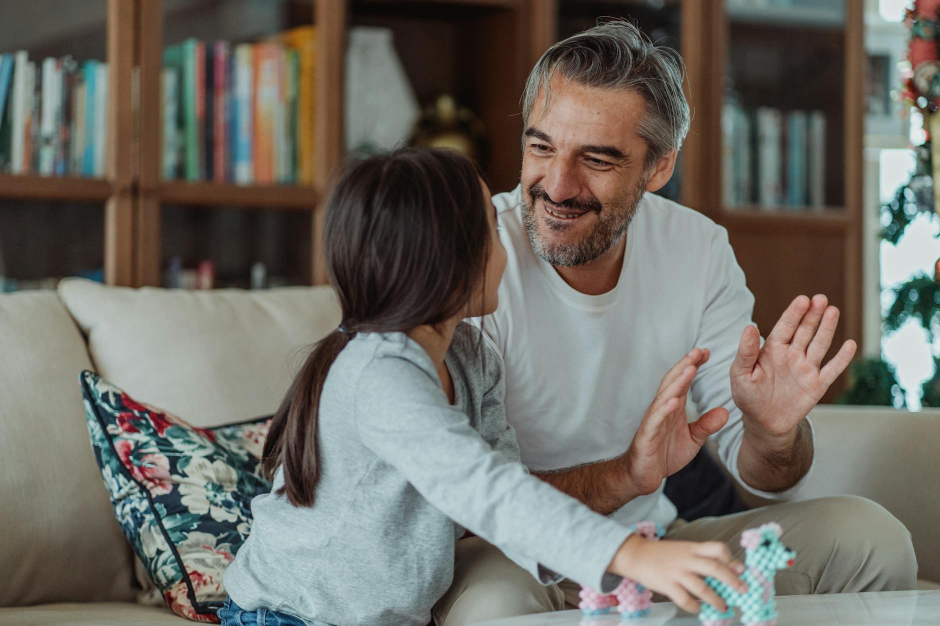 a girl holding toys while looking at her smiling father