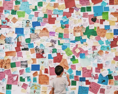 child looking at wall with memo card stickers