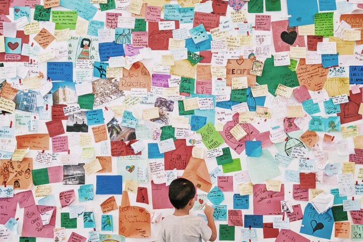 child looking at wall with memo card stickers