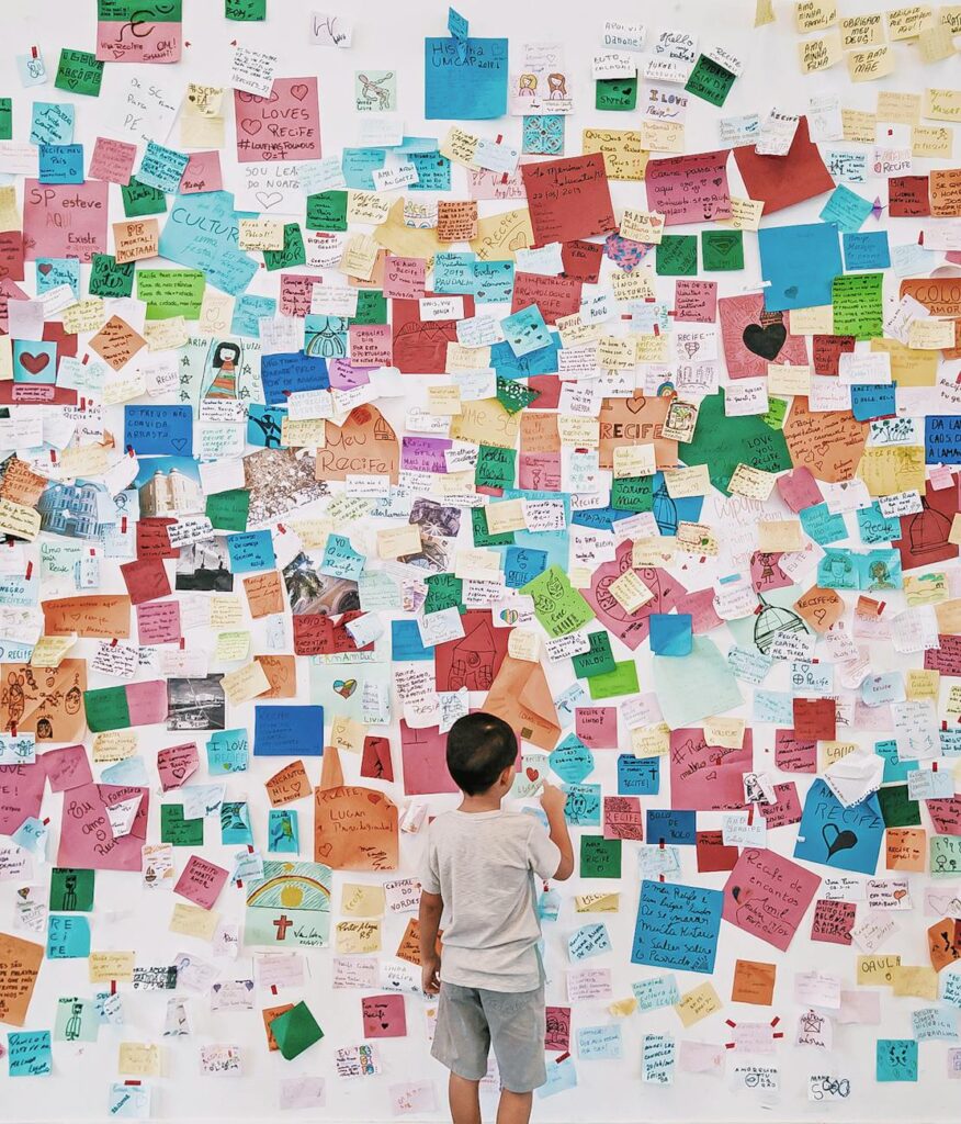 child looking at wall with memo card stickers