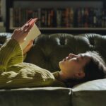 woman in yellow long sleeve shirt lying on couch
