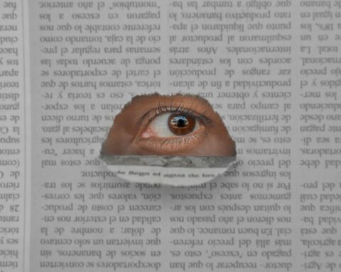 a brown eye on the hole of a newspaper