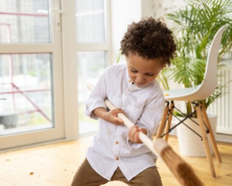 child playing with broom