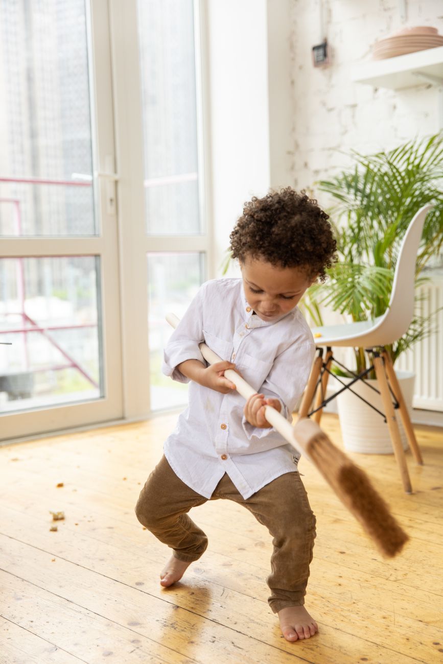 child playing with broom